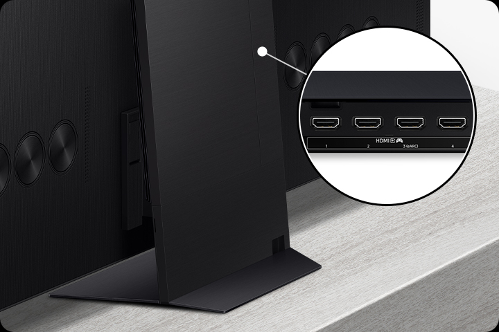 Один блок подключения крепится к задней части подставки телевизора. Крупным планом блока подключения видны 4 порта HDMI с игровым значком и опцией eARC.