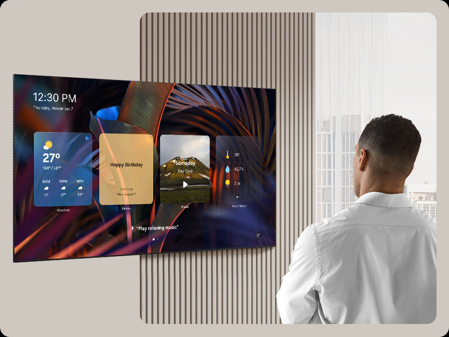 Человек, смотрящий на пустой экран телевизора. Экран активируется, чтобы отобразить «Ежедневные планы», на которых перемещаются виджеты «Погода», «Заметки», „Музыка“, «Домашняя статистика», «Samsung TV Plus» и «Советы». Также отображается время и дата, а также голосовая подсказка для воспроизведения расслабляющей музыки.